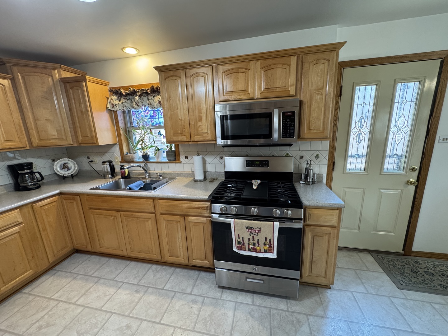 11117 South Ave L Chicago, IL 60617 - Photo 15 of 32 a kitchen with stainless steel appliances granite countertop a stove a sink and a microwave