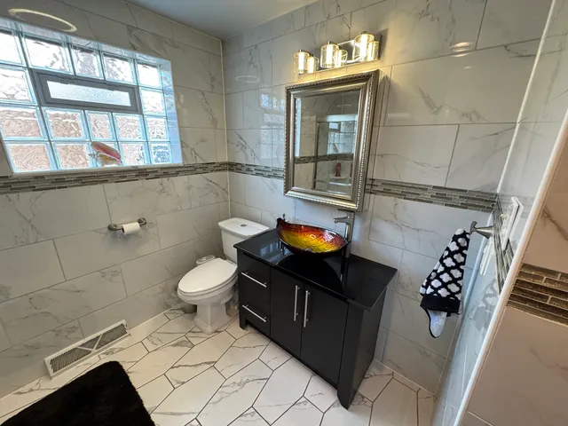 a bathroom with a toilet sink and mirror