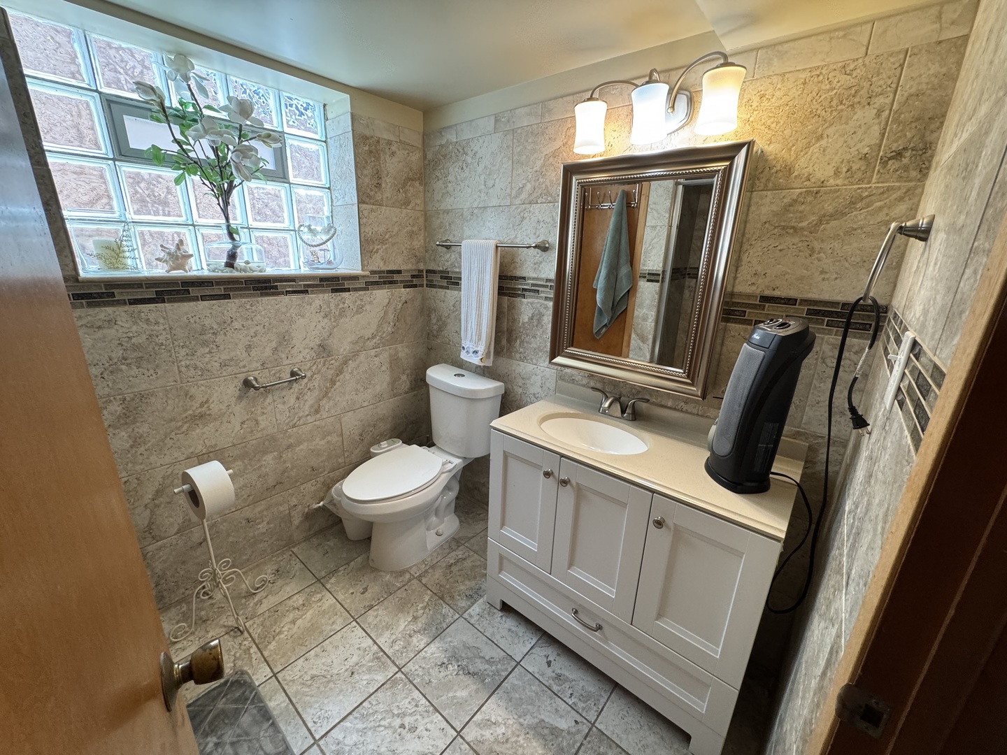 11117 South Ave L Chicago, IL 60617 - Photo 27 of 32 a bathroom with a toilet sink and mirror