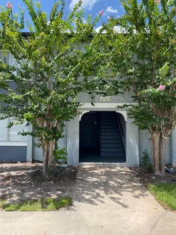 a front view of a house with a tree