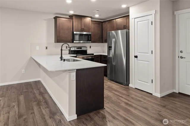 a kitchen with stainless steel appliances a refrigerator sink and microwave