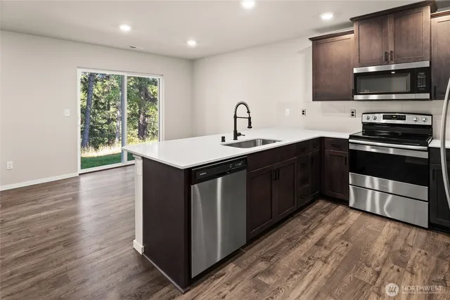 a kitchen with stainless steel appliances a stove sink microwave and cabinets