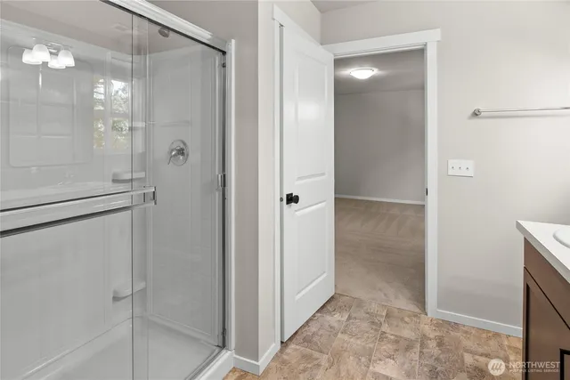 a bathroom with a shower and a glass door