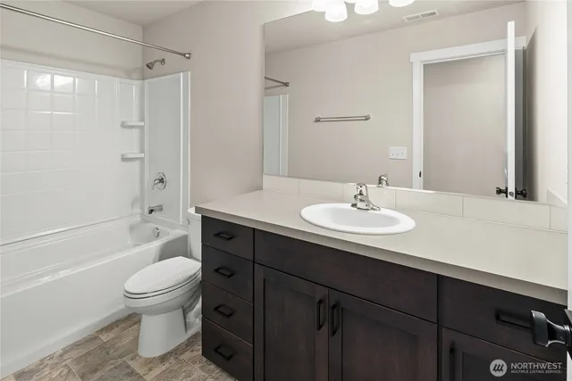 a bathroom with a sink a toilet and a large mirror