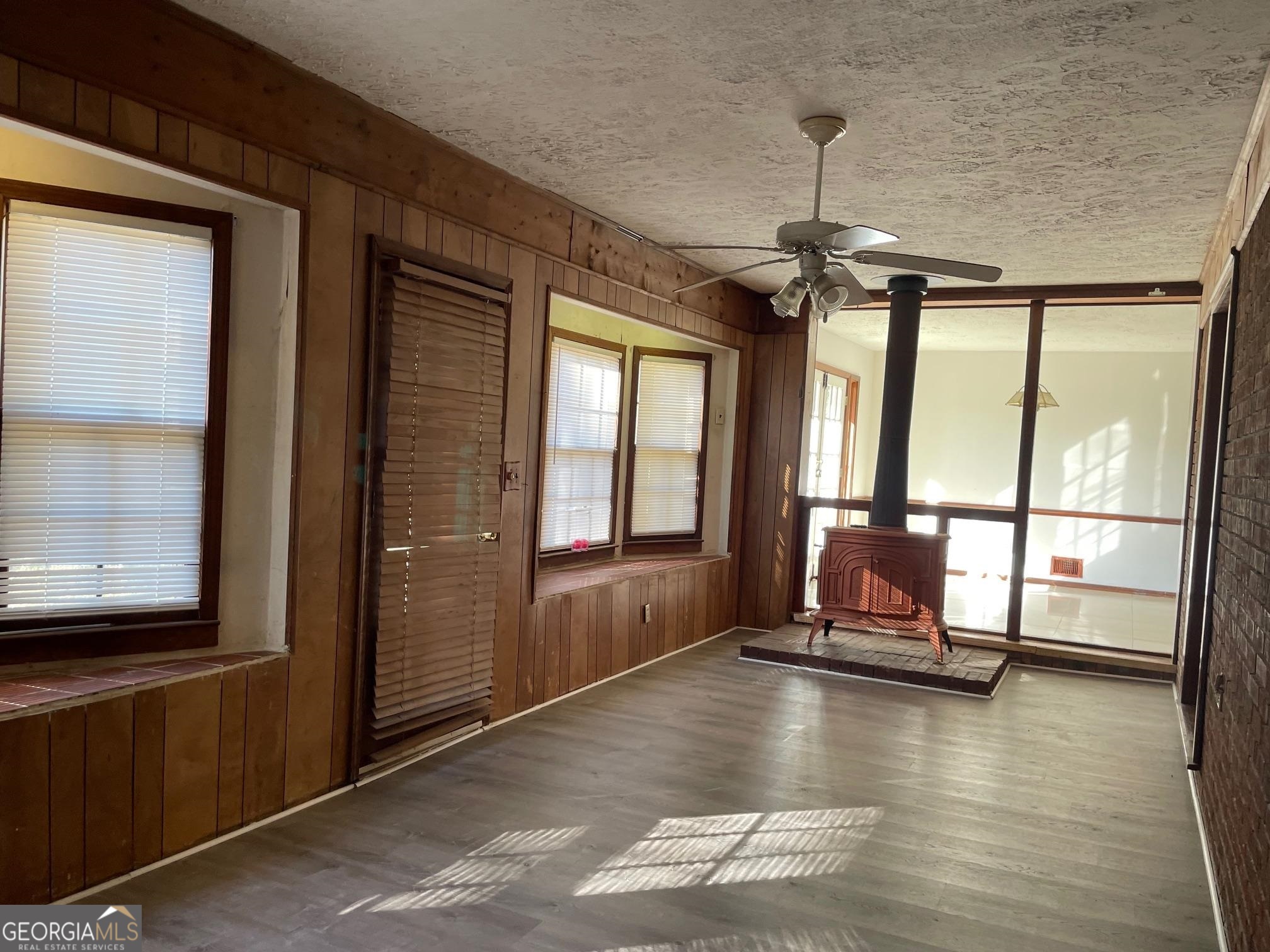 4231 Rue Dartagnan Stone Mountain, GA 30083 - Photo 12 of 23 a view of a livingroom with wooden floor a ceiling fan and windows