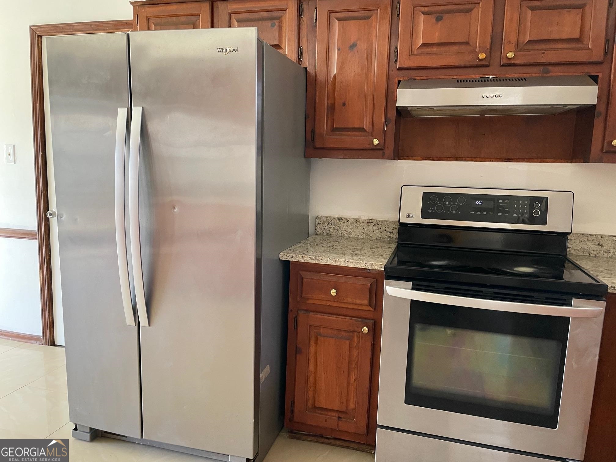 4231 Rue Dartagnan Stone Mountain, GA 30083 - Photo 16 of 23 a kitchen with granite countertop white cabinets and stainless steel appliances