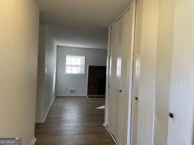 a view of a hallway with wooden floor and closet