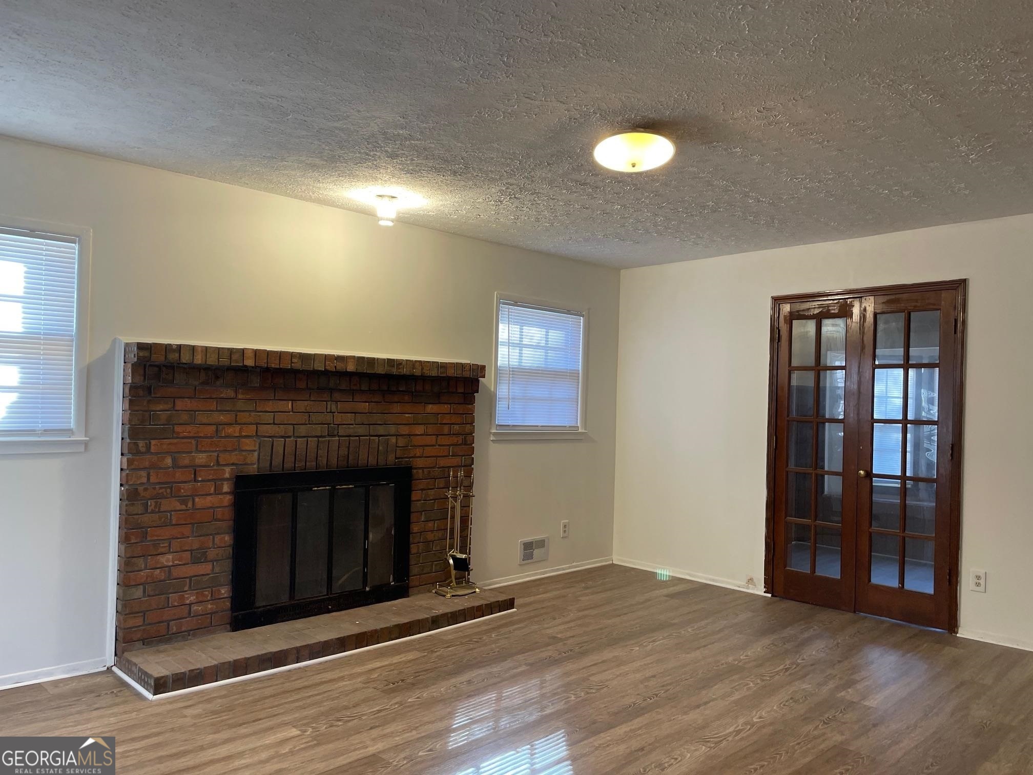 4231 Rue Dartagnan Stone Mountain, GA 30083 - Photo 5 of 23 a view of an empty room with wooden floor and a fireplace