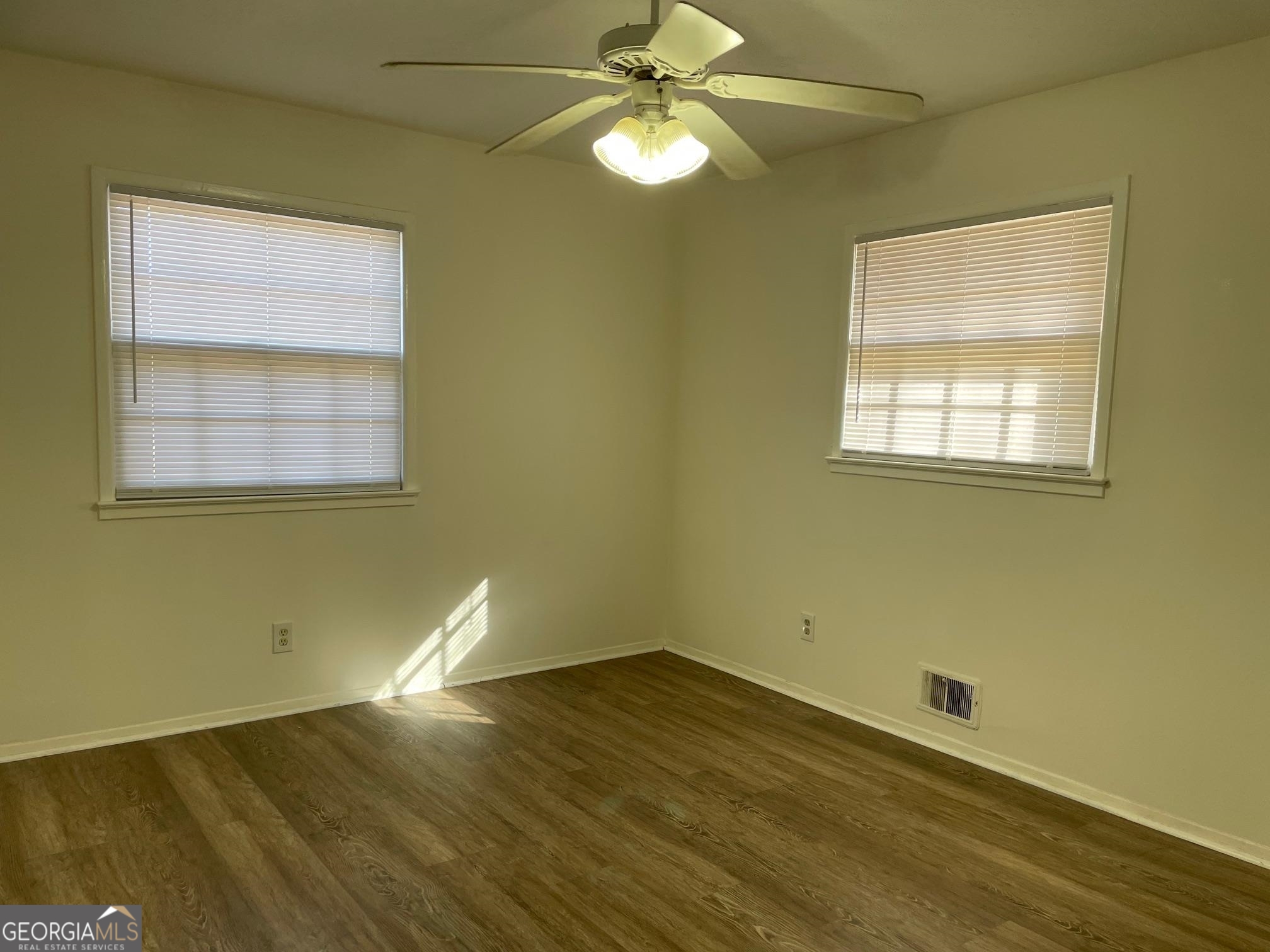4231 Rue Dartagnan Stone Mountain, GA 30083 - Photo 7 of 23 an empty room with wooden floor and windows