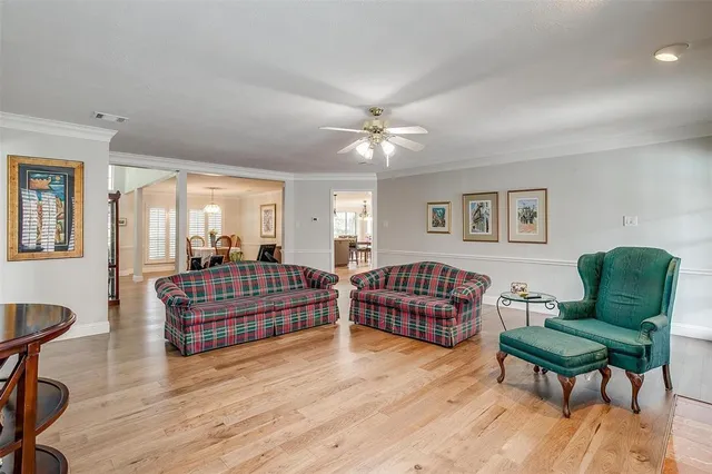 a living room with furniture a flat screen tv and kitchen view
