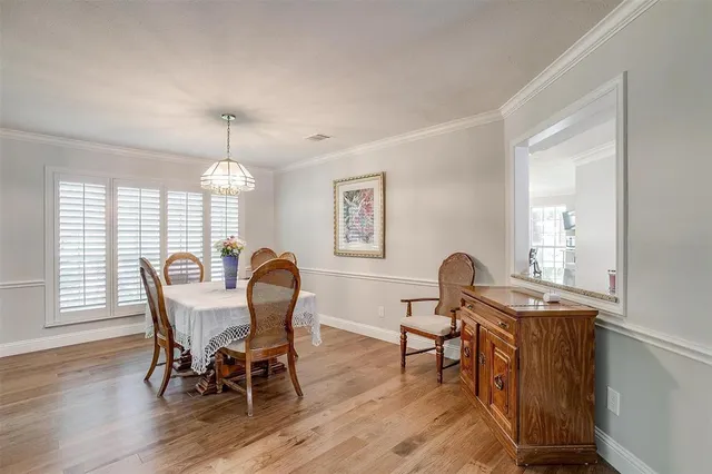 a view of a dining room with furniture a chandelier and wooden floor
