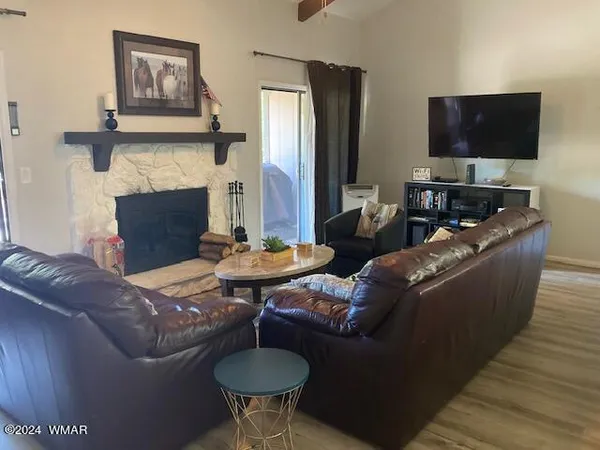 a living room with furniture a flat screen tv and a fireplace