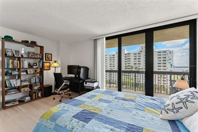 a bedroom with a bed a flat screen tv and a large window