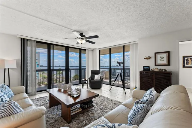 a living room with furniture ceiling fan and a floor to ceiling window