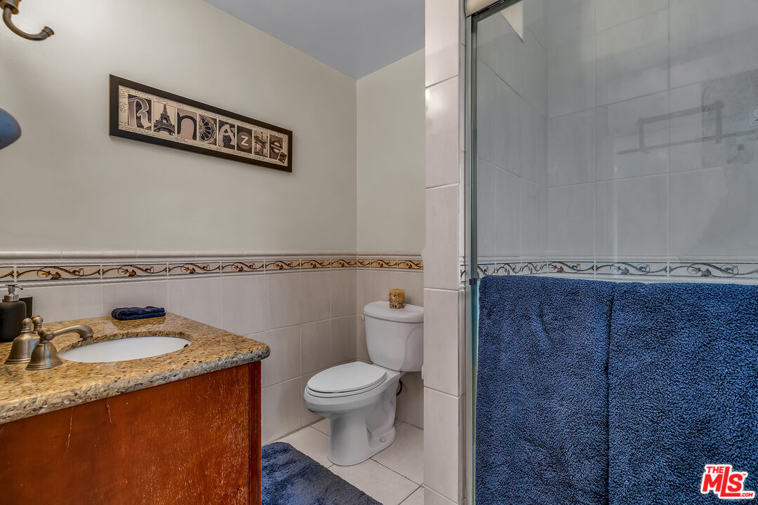 535 Winslow Avenue Long Beach, CA 90814 - Photo 13 of 32 a bathroom with a granite countertop sink and a toilet