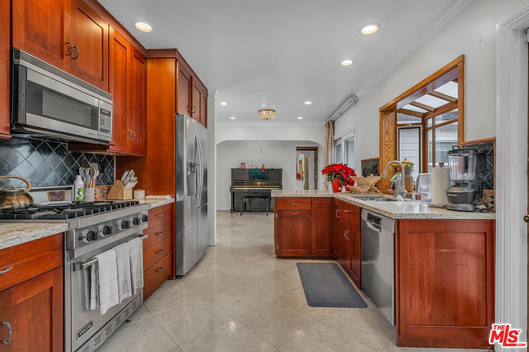 535 Winslow Avenue Long Beach, CA 90814 - Photo 9 of 32 a kitchen with stainless steel appliances granite countertop a stove top oven a sink dishwasher and a microwave oven with large wooden cabinets