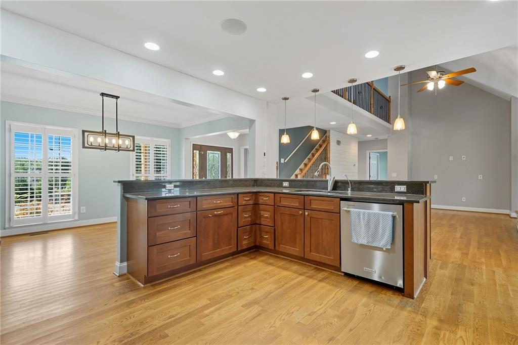 2347 Univeter Road Canton, GA 30115 - Photo 14 of 46 a kitchen with stainless steel appliances granite countertop a sink a stove and a wooden floors
