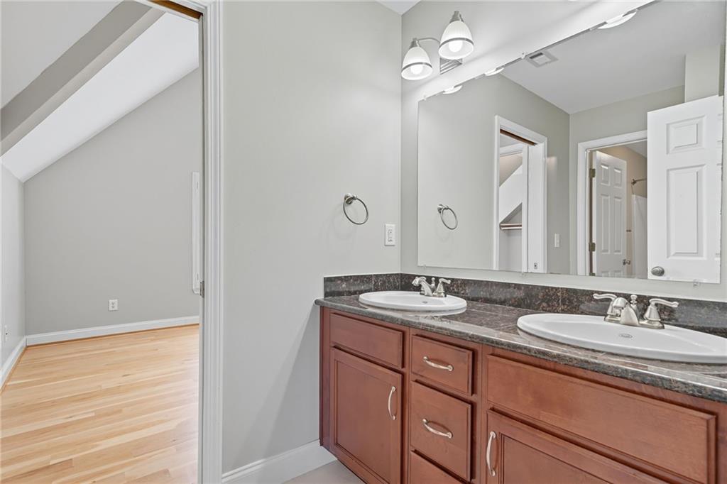 2347 Univeter Road Canton, GA 30115 - Photo 18 of 46 a bathroom with a granite countertop sink a light fixture and a mirror