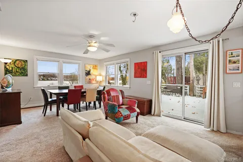a living room with furniture a chandelier and a large window