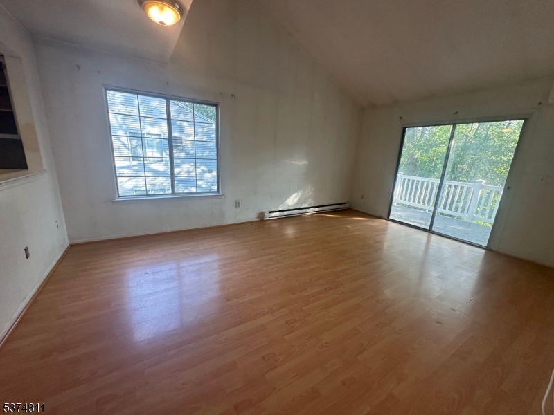 66 Mountain Court, Unit 66 Bedminster, NJ 07921 - Photo 4 of 18 an empty room with wooden floor and windows