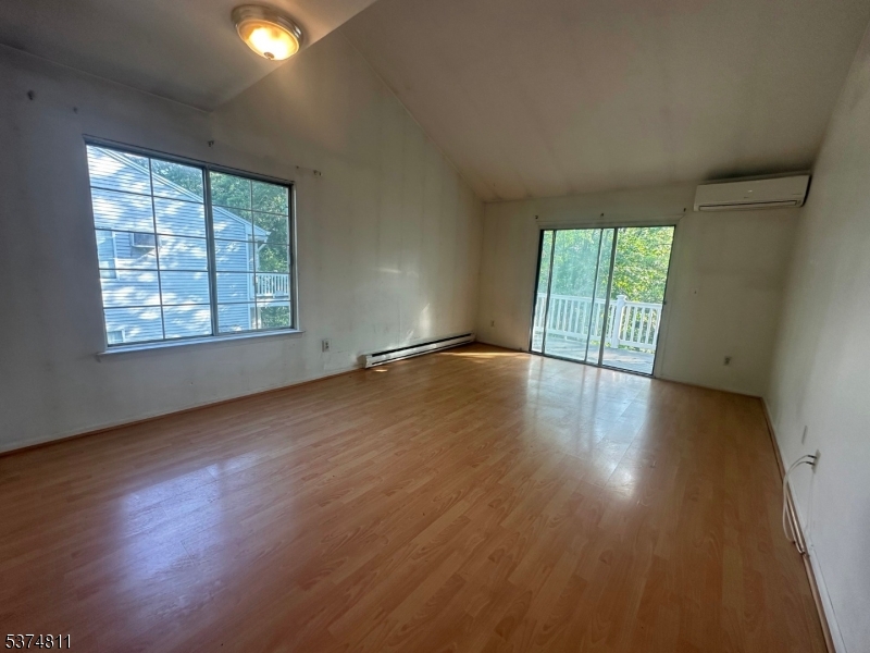 66 Mountain Court, Unit 66 Bedminster, NJ 07921 - Photo 5 of 18 an empty room with wooden floor and windows