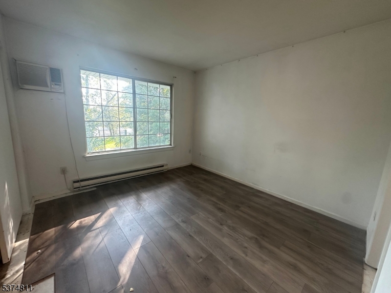 66 Mountain Court, Unit 66 Bedminster, NJ 07921 - Photo 8 of 18 an empty room with wooden floor and windows