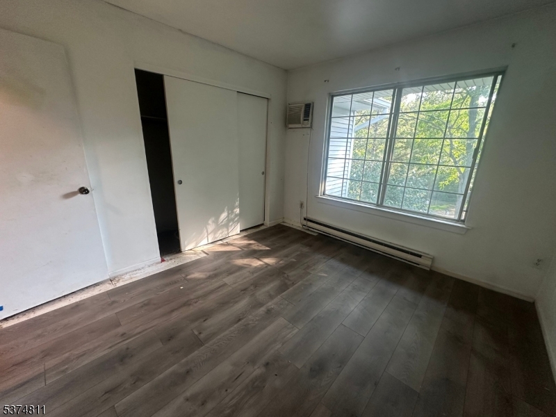 66 Mountain Court, Unit 66 Bedminster, NJ 07921 - Photo 9 of 18 an empty room with wooden floor and windows