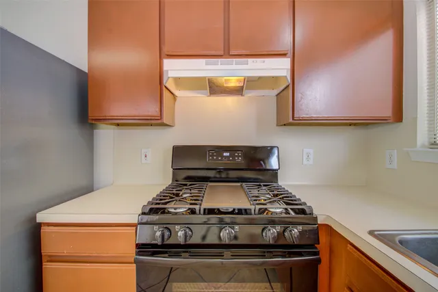 a stove top oven sitting inside of a kitchen