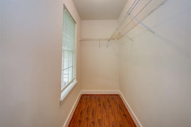 a view of a room with wooden floor and small window