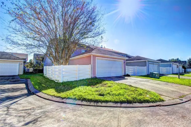 a view of a backyard with potted plants and large trees