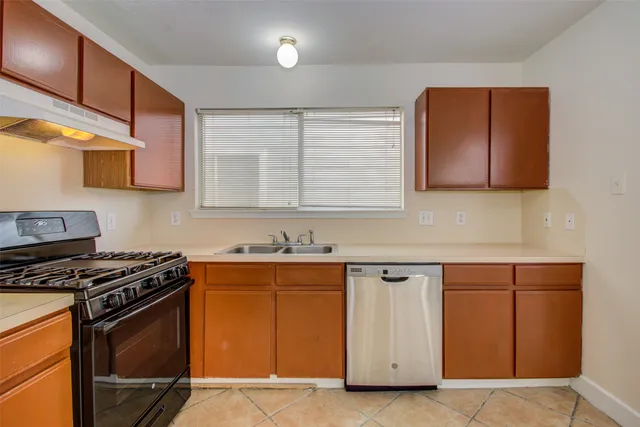a kitchen with granite countertop a stove top oven sink and cabinets