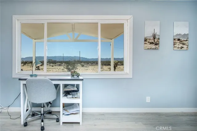 a view of a workspace with furniture and a window