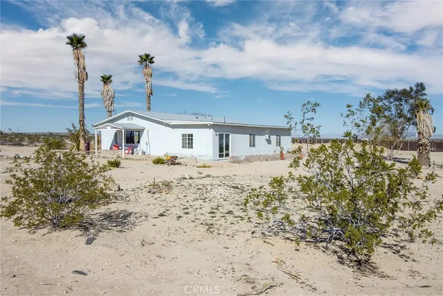 a front view of a house with a yard covered with snow
