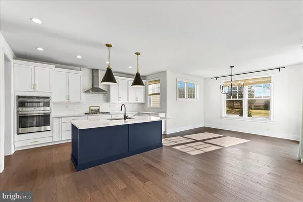 a large kitchen with stainless steel appliances kitchen island granite countertop a stove and a sink