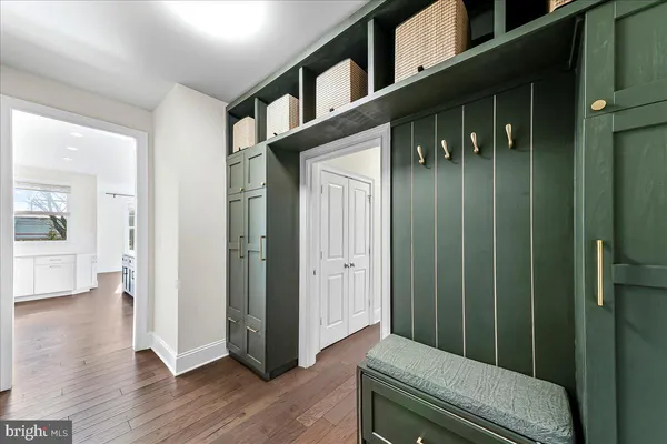 a hallway with wooden floor and stairs