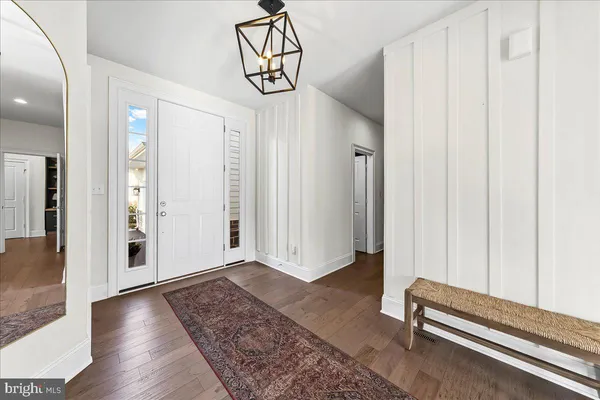 a view of a hallway with wooden floor and entryway