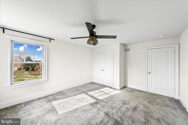 a view of a ceiling fan and window in a room