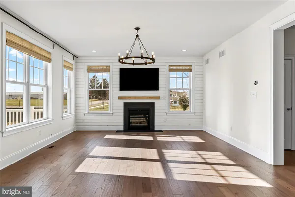 a living room with a fireplace furniture a flat screen tv and windows