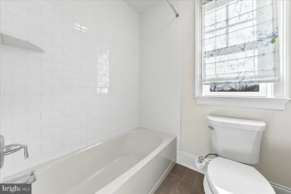 a white toilet sitting next to a bath tub