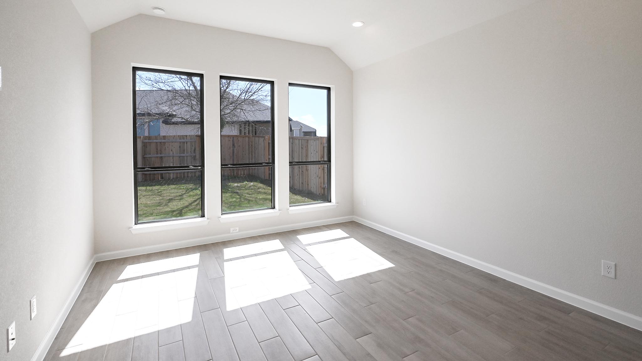 239 Prickly Poppy Loop Kyle, TX 78640 - Photo 8 of 26 an empty room with wooden floor and windows