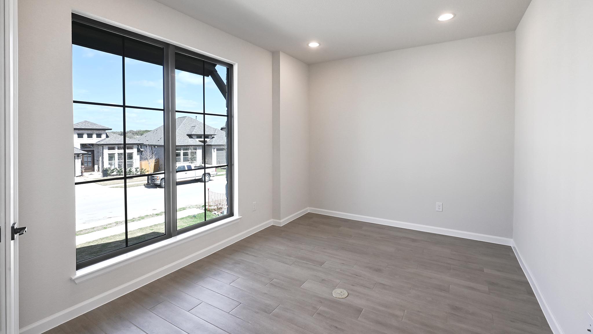 239 Prickly Poppy Loop Kyle, TX 78640 - Photo 10 of 26 an empty room with wooden floor and windows