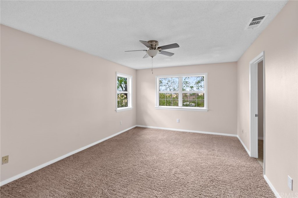 33796 Arthur Road Winchester, CA 92596 - Photo 14 of 54 an empty room with windows and a ceiling fan
