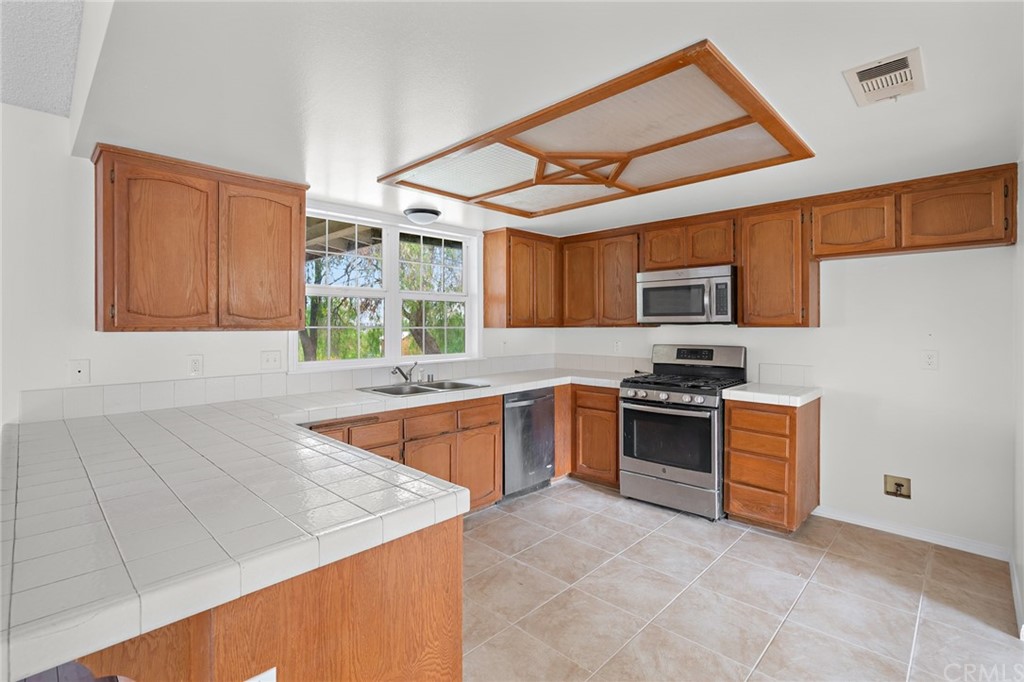 33796 Arthur Road Winchester, CA 92596 - Photo 5 of 54 a kitchen with stainless steel appliances granite countertop a stove a sink and a refrigerator