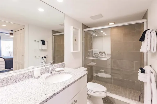 a bathroom with a granite countertop sink toilet and shower