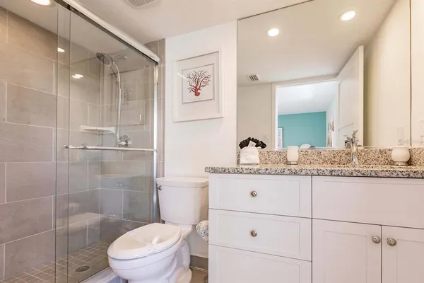 a bathroom with a sink a toilet and shower