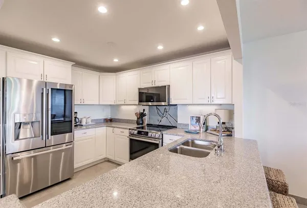 a kitchen with a sink a refrigerator and cabinets