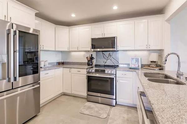 a kitchen with stainless steel appliances granite countertop a stove a sink and a refrigerator
