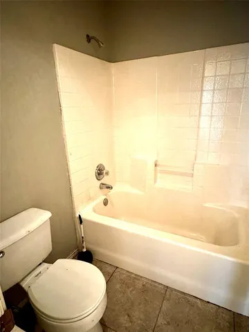 a white toilet sitting next to a bath tub