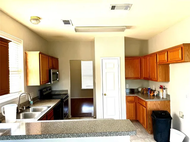 a kitchen with granite countertop a refrigerator and a sink