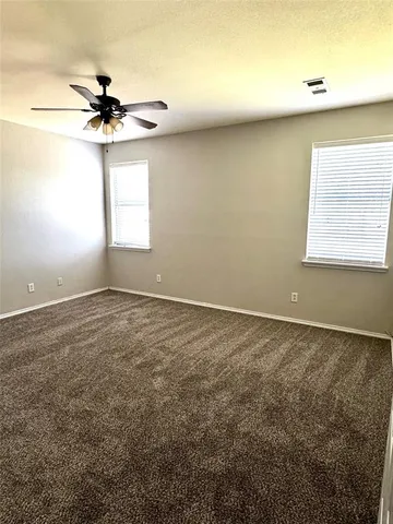 an empty room with a window and a fan